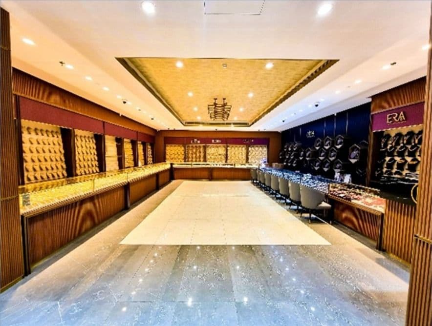 Jewellery showroom with a long marble floor, timber display walls and a gold coffered ceiling