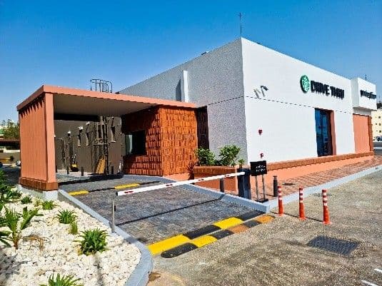Starbucks drive-thru building with a terracotta-tiled entrance block and landscaped forecourt